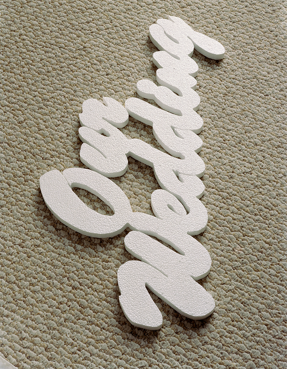 A photograph by Torbjorn Rodland depicting a styrofoam cutout with the words "Our Wedding" placed against a worn carpet